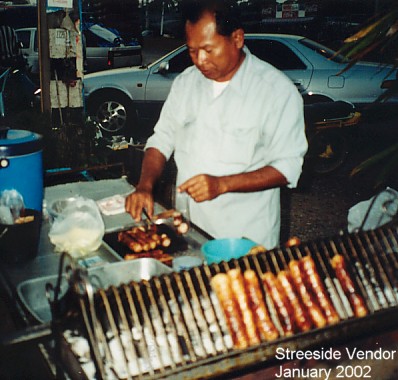 A street vendor cooking thai sausages - umm  umm g